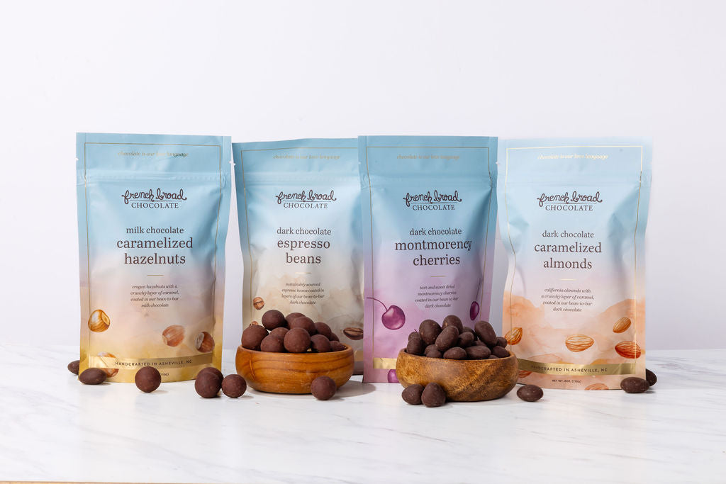 The Treat Yourself gift set: four French Broad snack pouches with bowls of chocolate-covered nuts